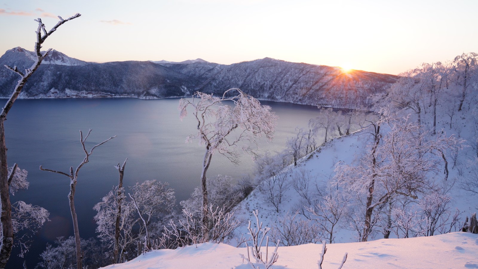 霧氷の木々と冬の摩周湖に昇る朝日